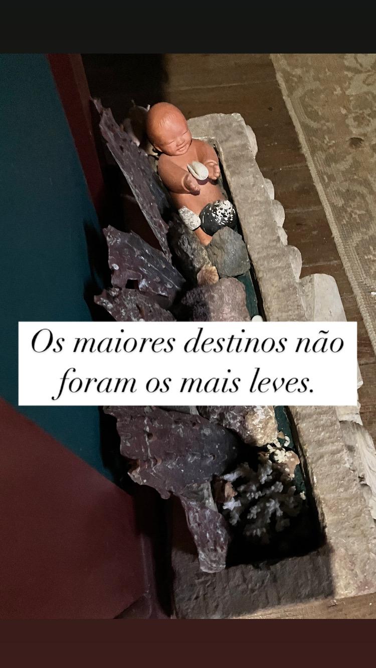 Figura de criança entre pedras - símbolo de proteção e renascimento