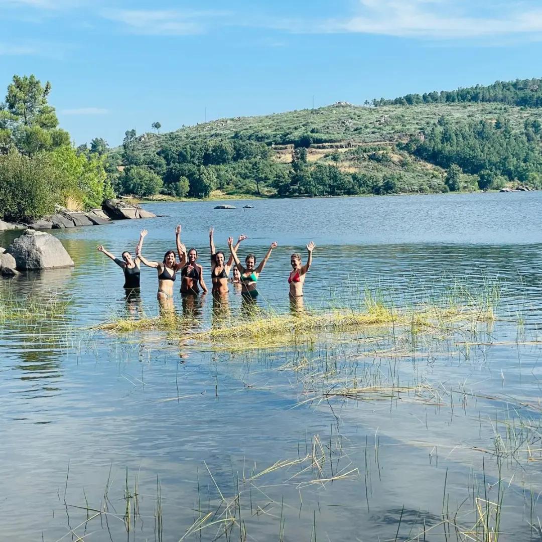 Grupo de mulheres a celebrar dentro de um lago em retiro